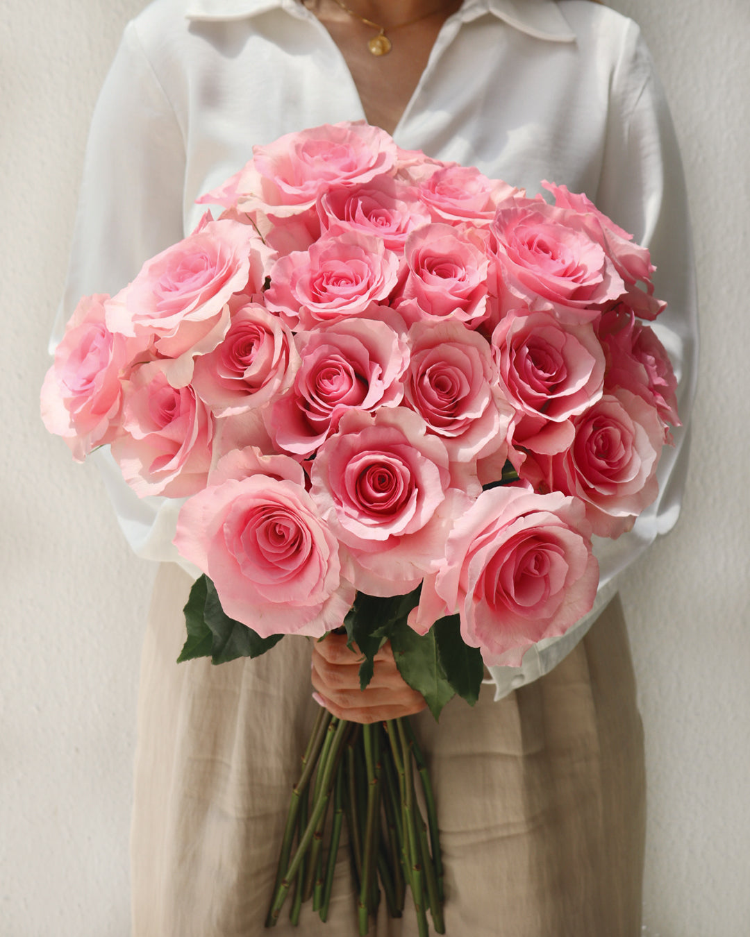 Soft pink roses held in a linen-toned setting